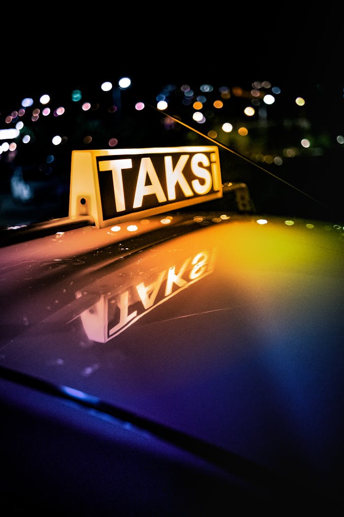 Close-up shot of a Turkish taxi sign with neon lights reflecting at night.
